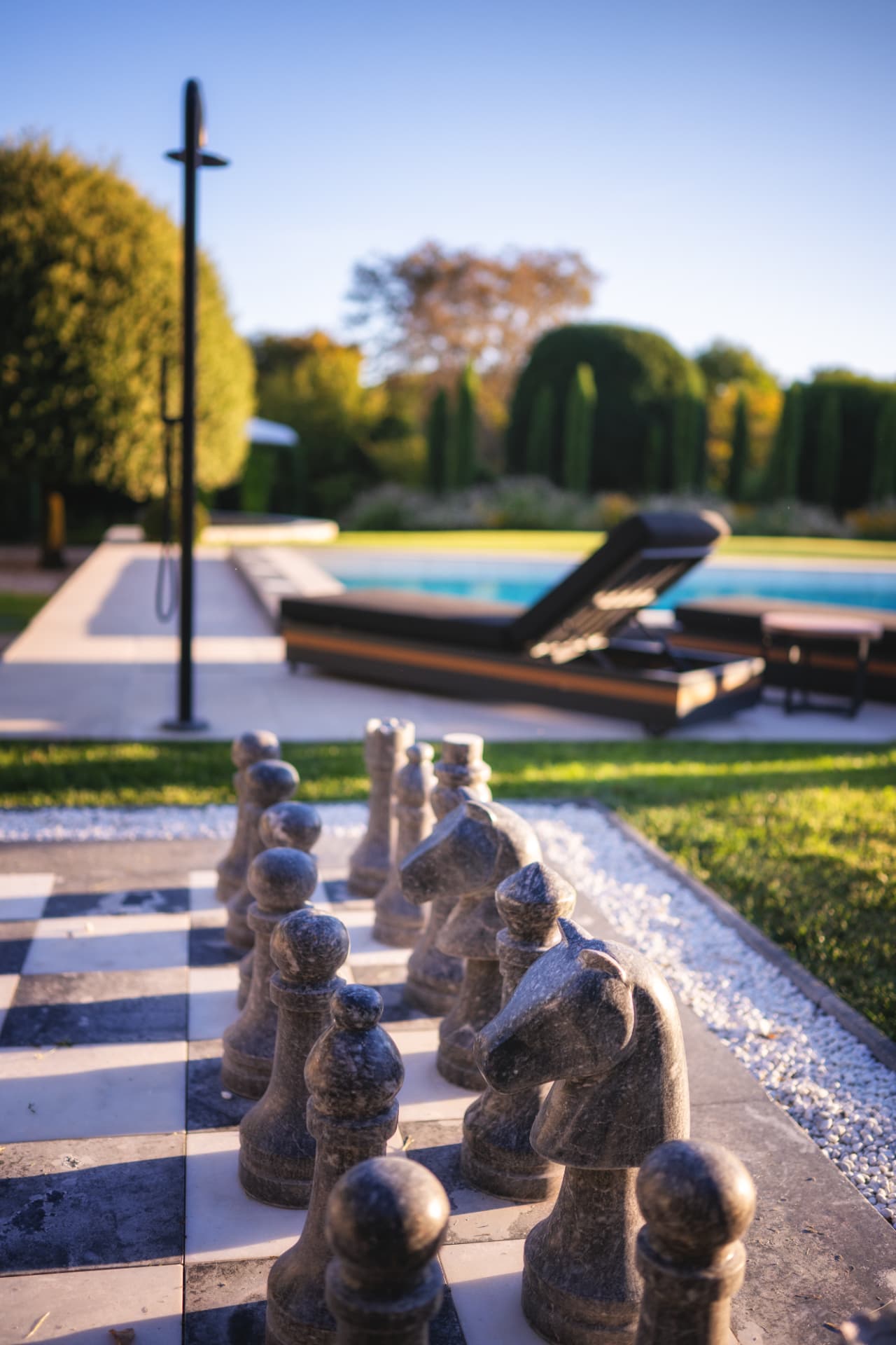 Échiquier géant en pierre au bord de la piscine du Château de Crâche