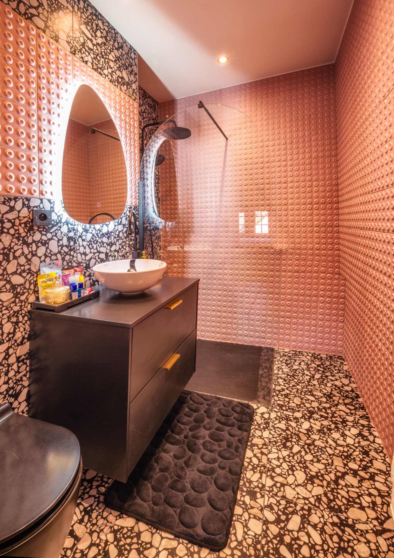 Salle de bain privative de la Suite Salève en terrazzo rose avec douche à l'italienne