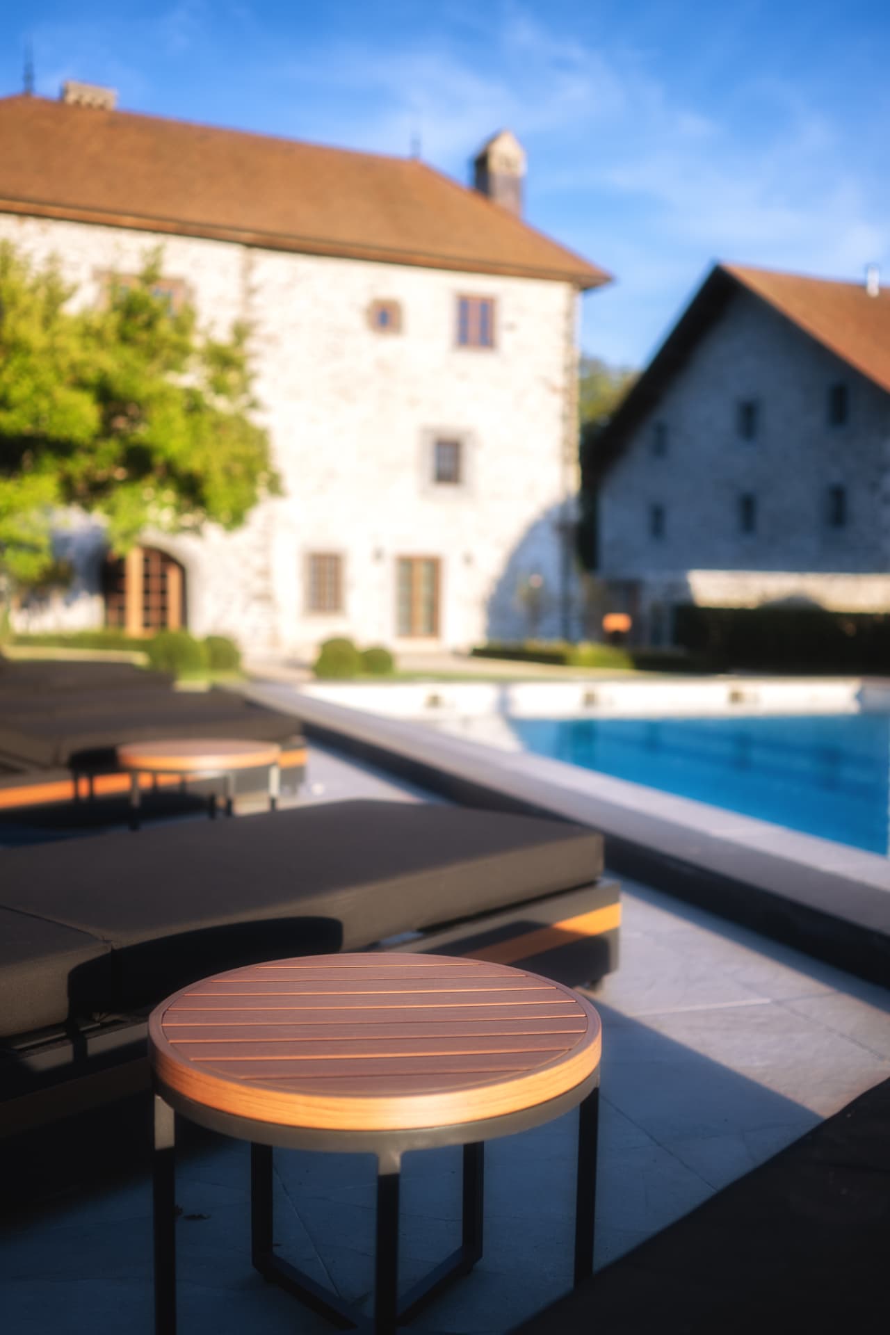 Transats au bord de la piscine chauffée devant la façade du Château de Crâche