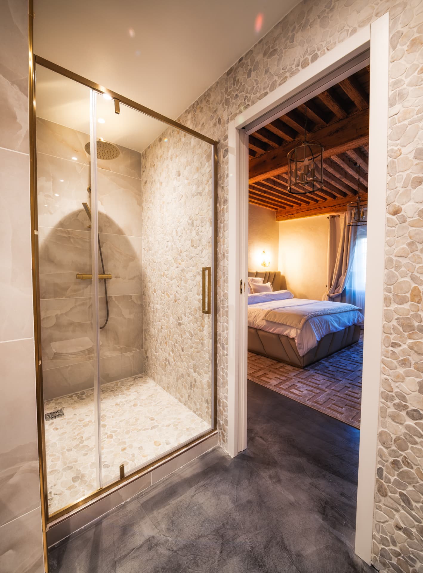Salle de bain privative minérale de la Suite Tour avec douche à l'italienne ouverte sur la chambre