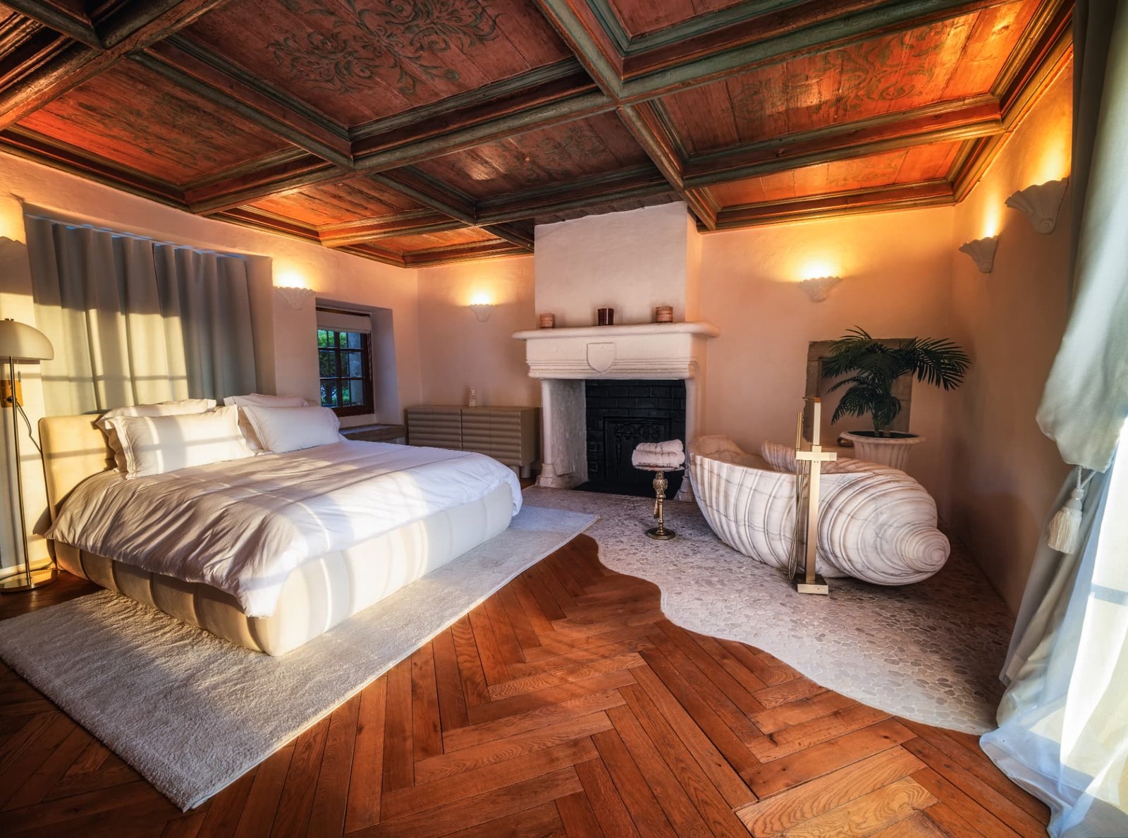 Suite du Maître au soleil couchant avec lit king, cheminée et baignoire îlot