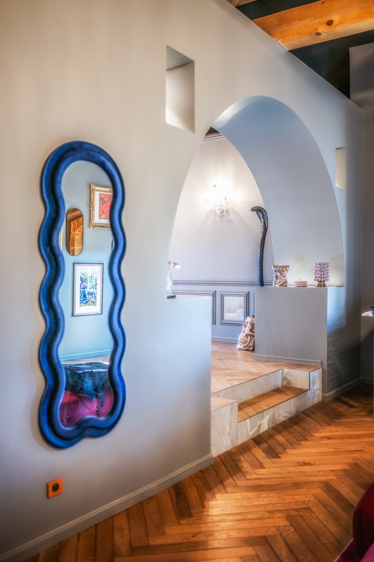 Passage aux arcades contemporaines du Château de Crâche, miroir bleu et œuvres d'art