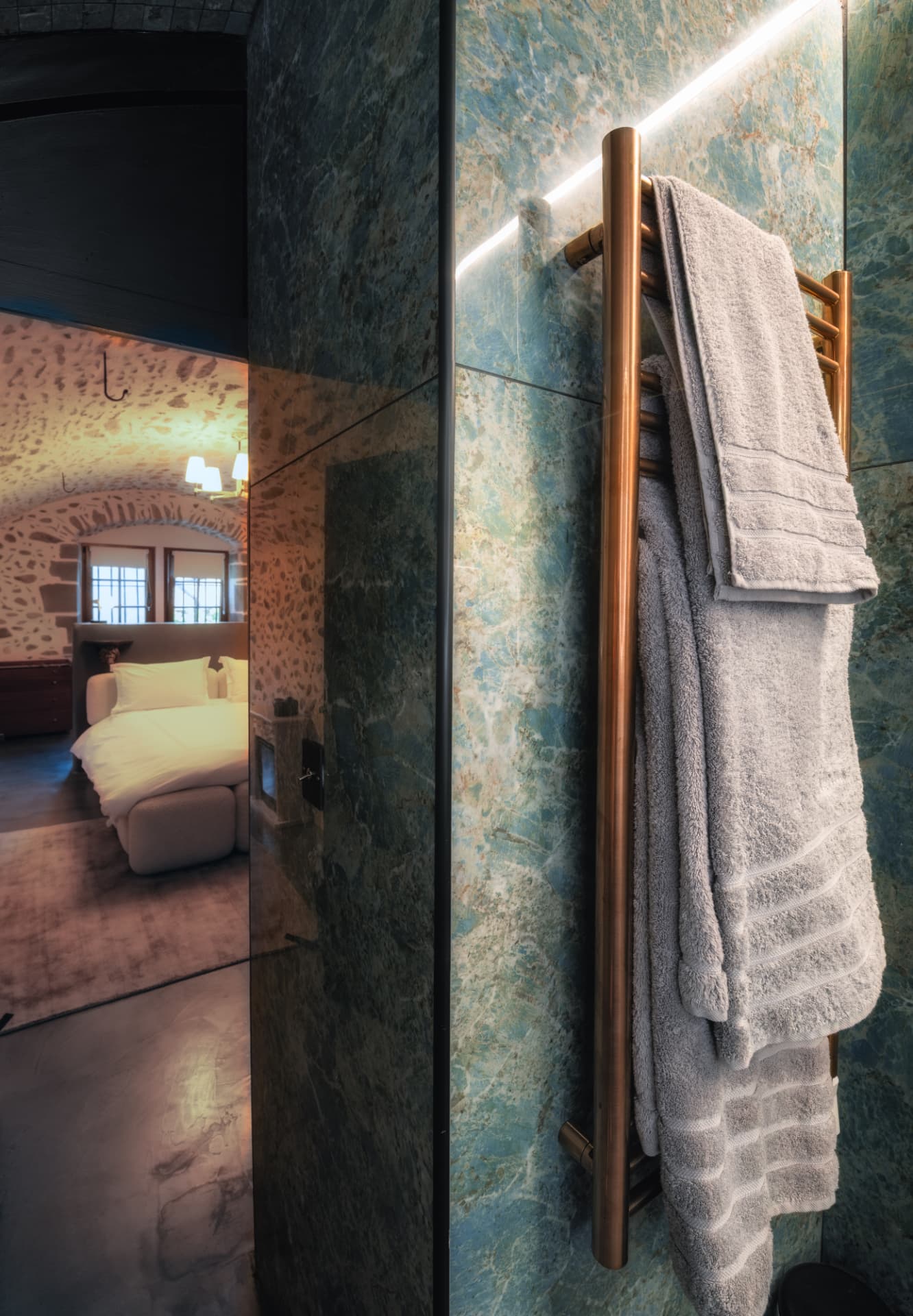 Salle de bain privative de la Suite Voûtée avec pierre bleue et sèche-serviettes en cuivre