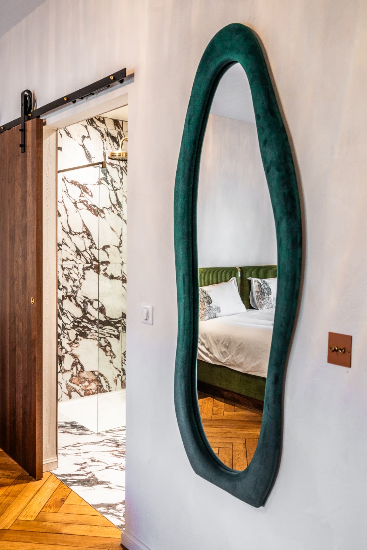 Miroir en velours vert de la Suite Bibliothèque ouvrant sur sa salle de bain en marbre